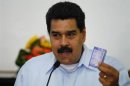 Venezuela's President Maduro holds a copy of the country's constitution during a news conference in Caracas