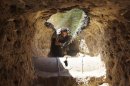 A Free Syrian Army fighter moves through a tunnel to take cover from snipers loyal to Syria's President Bashar al-Assad in Deir al-Zor