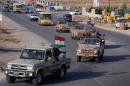 Kurdish peshmerga fighters drive in convoy through Arbil after leaving a base in northern Iraq on October 28, 2014 headed for the Syrian town of Kobane