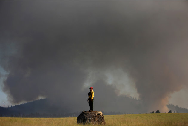 Marcus Johns with the Department of Natural Resources, watches as the Taylor Bridge Fire burns on the south side of Highway 970 near Swauk Prairie Road on Wednesday, Aug. 15, 2012 near Cle Elum, Wash.
