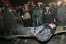 Anti-government protesters carry a wounded policemen during clashes with riot police in Kiev's Independence Square, the epicenter of the country's current unrest, Kiev, Ukraine, Wednesday, Feb. 19, 2014. Thousands of angry anti-government protesters clashed with police in a new eruption of violence following new maneuvering by Russia and the European Union to gain influence over this former Soviet republic. (AP Photo/Efrem Lukatsky)