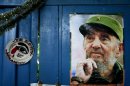 A poster of Cuba's Fidel Castro hangs on the wall of a food market next to plate that reads in Spanish "I'm looking at you" in Havana, Cuba, Tuesday, Aug. 13, 2013. Castro turns 87 on Tuesday. Castro's brother Raul Castro has been in power since a near-fatal illness forced Fidel to step aside in 2006. (AP Photo/Franklin Reyes)