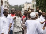 An elder tries to calm a group of youths protesting against the killing of Sheikh Aboud Rogo Mohammed, after Friday prayers at the Mewa mosque in Mombasa