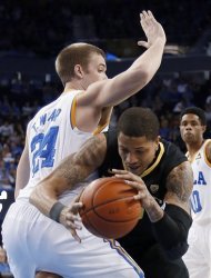Oregon center Tony Woods (55) tries to pass UCLA forward Travis Wear (24) in the first half of an NCAA college basketball game in Los Angeles on Saturday, Jan. 19, 2013. (AP Photo/Reed Saxon)