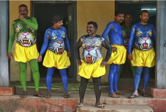 Dancers in body paint wait to take part in a performance during festivities marking the start of the annual harvest festival of "Onam" in the southern Indian city of Kochi