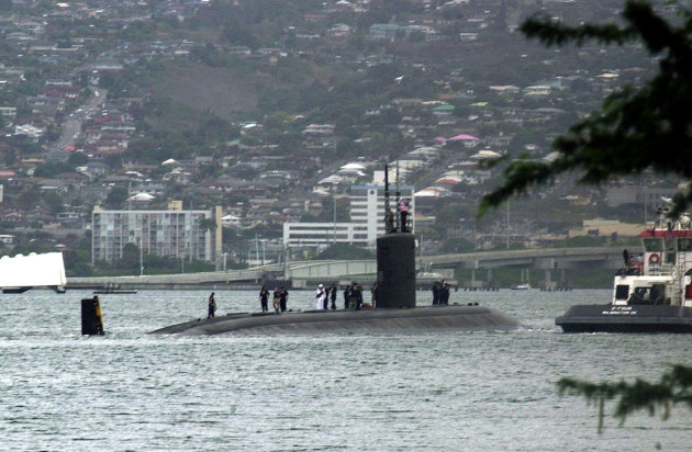 FILE - The submarine USS Greeneville is escorted to the submarine base at Pearl Harbor, in this Feb. 10, 2001, file photo. A high concentration of important military commands and facilities on the island mean there's a great deal of information in Hawaii that potential adversaries want to know. (AP Photo/Ronen Zilberman)