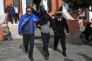 Policemen escort to the Alexandroupolis courthouse two of the three Britons arrested near the Greek border with Turkey, where they were suspected of heading to join Kurdish forces fighting Islamic State jihadists, on February 16, 2016