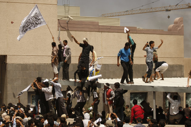A Yemeni protestor, left, holds a white flag with Islamic inscription in Arabic that reads, "No God but Allah, and Mohammed is his prophet," in front of the U.S. embassy during a protest about a film ridiculing Islam's Prophet Muhammad, in Sanaa, Yemen, Thursday, Sept. 13, 2012. Dozens of protesters gather in front of the US Embassy in Sanaa to protest against the American film "The Innocence of Muslims" deemed blasphemous and Islamophobic. (AP Photo/Hani Mohammed)