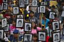 FILE - In this April 26, 2016 file photo, family members and supporters of 43 missing teachers college students carry pictures of the students as they march to demand the case not be closed and that experts' recommendations about new leads be followed, in Mexico City. The most recent forensic investigation of the southern Mexico garbage dump where the government says 43 students were incinerated did not confirm there was a fire there that night. It shows the experts found evidence the Cocula dump had been the site of at least five fires, but could not determine when. Remains of 17 people were also found, but it was unknown when they were burned. (AP Photo/Rebecca Blackwell, File)
