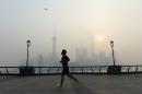 A man exercises amid heavy smog on the Bund in Shanghai on November 12, 2014