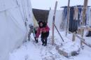 Syrian refugees play with snow at the makeshift refugee camp of Terbol, near the Bekaa Valley town of Zahleh in eastern Lebanon, on December 11, 2013