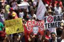 Demonstrators hold up posters that read in Portuguese "Direct elections now," left, "Coup", center, and "Get out Temer," right, during a protest against Brazil's President Michel Temer after a military Independence Day parade in Brasilia, Brazil, Wednesday, Sept. 7, 2016. Brazil's former President Dilma Rousseff was removed from office for breaking fiscal responsibility laws in her management of the federal budget. Temer, once her vice president, will serve out her term which runs through 2018. (AP Photo/Eraldo Peres)
