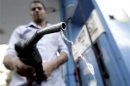 A worker holds up a fuel pump nozzle after filling up the tank of a car at a petrol station in Cairo