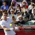 Andy Murray of Britain returns a shot to Stanislas Wawrinka of Switzerland in front of spectators shielding from the sun during their men's singles quarter-finals match at the Japan Open tennis championships in Tokyo