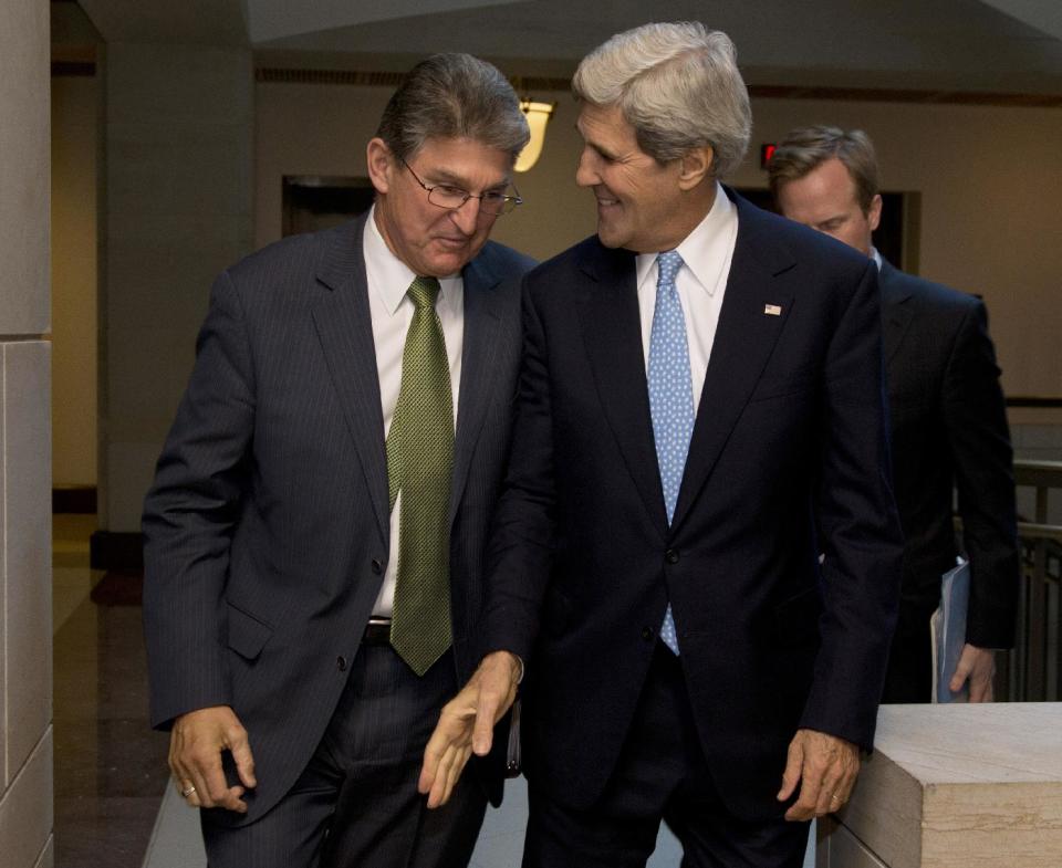 Secretary of State John Kerry walks with Senate Banking Committee member Sen. Joe Manchin, D-W. VA., to a meeting with the committee on Capitol Hill in Washington, Wednesday, Nov. 13, 2013. Kerry and top U.S. nuclear negotiator Wendy Sherman hope to persuade members of the Senate Banking Committee in their meeting Wednesday to hold off on additional punitive measures on the Iranian economy. After, Biden and the Treasury Department's sanctions chief, David Cohen, will join them for a separate briefing with Senate Democratic leaders. (AP Photo/Carolyn Kaster)