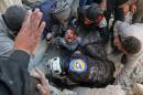 Syrian civil defence volunteers, known as the White Helmets, rescue a boy from the rubble following an attack on the Bab al-Nairab neighbourhood of Aleppo on November 24, 2016