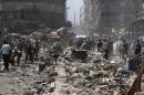 People inspect a site hit by what activists said were air strikes by forces loyal to Syria's President Bashar al-Assad on a marketplace in the Douma neighborhood of Damascus, Syria