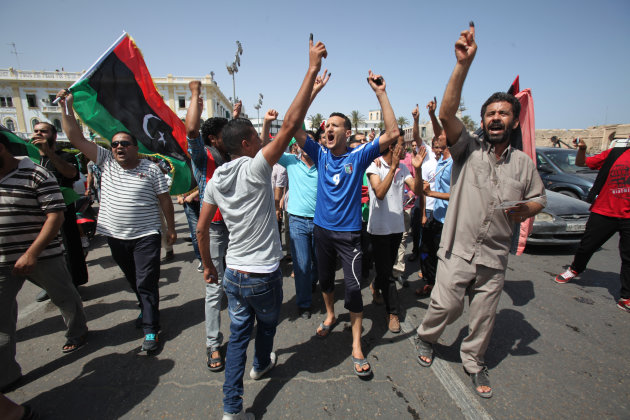 Libyans hold up their ink-marked fingers that shows they have voted as they celebrate in Martyrs' Square in Tripoli, Libya, Saturday, July 7, 2012. Jubilant Libyan voters marked a major step toward democracy after decades of erratic one-man rule, casting their ballots Saturday in the first parliamentary election after last year's overthrow and killing of longtime leader Moammar Gadhafi. But the joy was tempered by boycott calls, the burning of ballots and other violence in the country's restive east. (AP Photo/Abdel Magid Al Fergany)