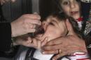 An activist health worker administers a polio vaccination to a child in Aleppo