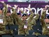 British Army soldiers perform a "Mexican Wave" as they watch men's beach volleyball