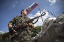 A pro-Russian separatist guards a road checkpoint outside the town of Lysychansk in Luhansk