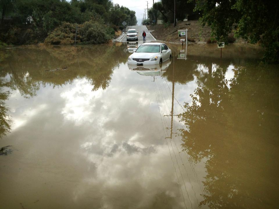 A car sits partially submerged in flood waters on Hemet Street in Hemet, Calif., Thursday morning, Dec. 4, 2014, after overnight rains doused the area...