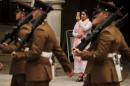 A woman uses a smart phone to photograph members of the Yorkshire Regiment as they parade in Bradford, Britain