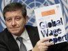 Ryder Director-General of the ILO poses with a copy of the Global Wage Report after a news conference at the United Nations in Geneva