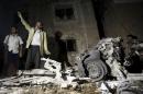 Man reacts as he stands next to wreckage at the site of a car bomb attack outside his house in Yemen's capital Sanaa