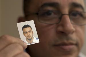 Mohamed Nidalha poses with a passport photo of his &hellip;