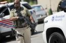 A US Marshal takes his position outside the federal court in Washington before the vehicles reportedly transporting the Libyan militant Ahmed Abu Khattala leave following Khattala's detention hearing, Wednesday, July 2, 2014. (AP Photo/Pablo Martinez Monsivais)
