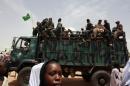 A Sudanese girl walks past a truck carrying leaving soldiers following a visit by President Omar al-Bashir in the West Darfur state capital of El Geneina on July 24, 2008