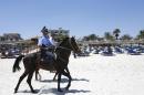 FILE - In this June 28 2015 file photo, mounted police officers patrol on the beach of Sousse, Tunisia. The blood on the sand has washed away, but the damage wreaked on Tunisia by a few terrifying minutes of gunfire at a beach resort will be deep and lasting. The tourist economy is likely to be gutted: Up to 2 million hotel nights per year are expected to be lost, hastened by warnings from Britain and other European governments last week that their citizens are no longer safe on . (AP Photo/Abdeljalil Bounhar, File)