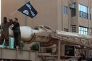An image made available by Jihadist media outlet Welayat Raqa on June 30, 2014, allegedly shows a member of the Islamic state militant group parading with a long-range missile on a street in Raqa, Syria