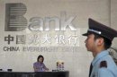 A security personnel on duty stands next to the reception desk at a branch of China Everbright Bank in Hefei