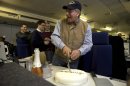The traveling staff on board the E-4B surprise U.S. Defense Secretary Leon Panetta with a cake that says "arrivederci," in a celebration in honor of the last leg of his final overseas trip as secretary, en route to Washington on Saturday, Jan. 19, 2013. The plastic meat axe at right was a joke gift from the staff, at the secretary's reference to budget sequestration being a meat axe. (AP Photo/Jacquelyn Martin)