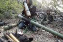 A rebel fighter checks a launcher near the village of Kasab and the border crossing with Turkey, in the northwestern province of Latakia, on March 24, 2014