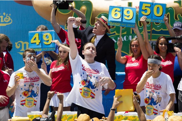 Joey "Jaws" Chestnut - with a mouthful of hot dog - punches the air in victory as he wins the Nathan's Famous Fourth of July International Hot Dog Eating contest. He chomped on a total o