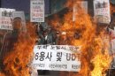 South Korean conservative activists burn cutout pictures of North Korean national founder the late Kim Il Sung, right, and late leader Kim Jong Il during a rally to mark the third anniversary of the sinking of South Korean naval ship "Cheonan" which killed 46 South Korean sailors, in Seoul, South Korea, Tuesday, March 26, 2013. An explosion ripped apart the 1,200-ton warship, killing 46 sailors near the maritime border with North Korea in 2010. A banner reads: "Bomb at statue of Kim Jong Il and Kim Il Sung." (AP Photo/Ahn Young-joon)