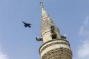 A Turkish Air Force F-4E fighter flies over a minaret after taking off from Incirlik air base in Adana, Turkey
