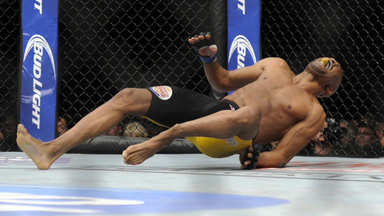 EDS NOTE GRAPHIC CONTENT: Anderson Silva, right, of Brazil, screams after kicking Chris Weidman of Baldwin, N.Y., and injuring his leg during the UFC 168 mixed martial arts middleweight championship bout on Saturday, Dec. 28, 2013, in Las Vegas. Weidman won during the second round by a technical knock out after the kick by Silva. (AP Photo/David Becker)