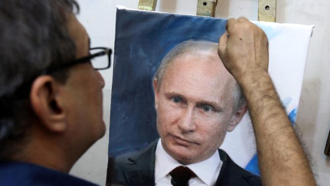 Iraqi artist Mohammed Karim Nihaya touches up a painting of Russian President Vladimir Putin in his . - Part-NIC-Nic6493470-1-1-0