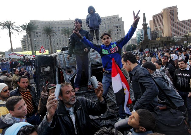 Egyptian protesters celebrate the capture of a state security armored vehicle that demonstrators commandeered during clashes with security forces and brought to Tahrir Square in Cairo, Egypt, Tuesday, Jan. 29, 2013. Egypt’s army chief warned Tuesday of the “the collapse of the state” if the political crisis roiling the nation for nearly a week continues, but said the armed forces will respect the right of Egyptians to protest. (AP Photo/Amr Nabil)