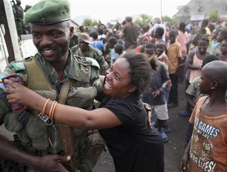 A woman greets a government army FARDC soldier as he returns to Goma December 3, 2012. REUTERS/Goran Tomasevic