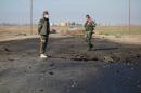 In this undated photo made avaialble Saturday, March 14, 2015, by the Kurdistan Region Security Council (KRSC), Kurdish soldiers survey the site of a bomb attack on a road between Mosul, Iraq, and the Syrian border in northern Iraq. Kurdish authorities in Iraq said Saturday they have evidence that the Islamic State group used chlorine gas as a chemical weapon against peshmerga fighters, the latest alleged atrocity carried out by the extremist organization now under attack in Tikrit. (AP Photo/Kurdistan Region Security Council)