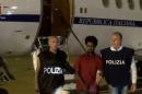 Medhanie Yehdego Mered is pictured with Italian policemen as they land at Palermo airport, Italy, following his arrest in Khartoum, Sudan