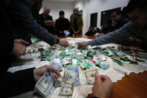 Palestinians count money during a fundraising campaign &hellip;