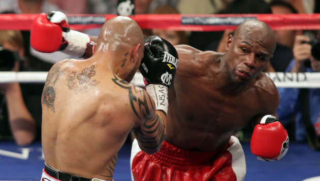 Floyd Mayweather (R) throws a right at the head of Miguel Cotto during their WBA super welterweight title fight at the MGM Grand in Las Vegas on May 5, 2012. Mayweather won the WBA super welterweight title with a 12-round unanimous decision.     AFP PHOTO/John GurzinskiJOHN GURZINSKI/AFP/GettyImages