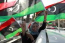 A woman celebrates on the streets after casting her vote during the National Assembly election in Tripoli's Martyrs square