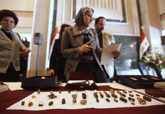 Pegawai memeriksa artifak di Kementerian Luar Negeri Irak di Baghdad 30 Januari 2012. Vas emas Sumeria berusia 6500 tahun, kepala kapak perang Sumeria dan batu dari istana Assyria adalah 45 relik yang